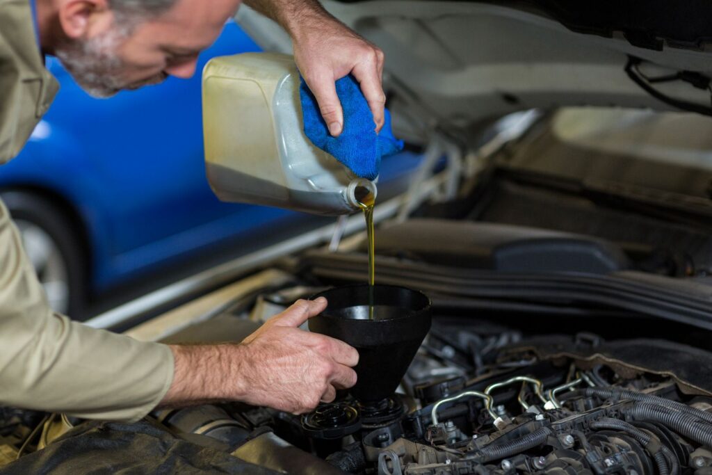 compressed_mechanic-pouring-oil-into-car-engine