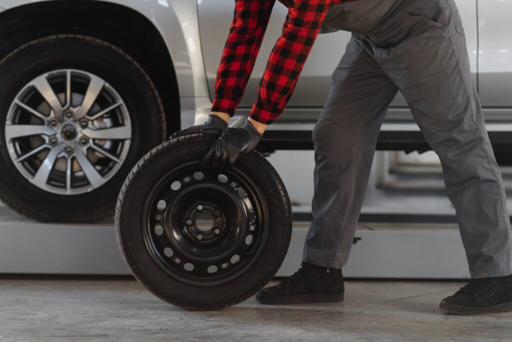 mechanic-holding-a-tire-tire-at-the-repair-garage-2025-03-15-05-15-04-utc-min
